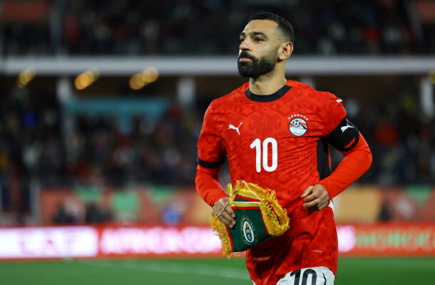 Football - 2025 Africa Cup of Nations - Egypt v Zimbabwe - Adrar Stadium - Agadir | Ghanaguardian.com Soccer player in a red jersey with number 10 holding a ceremonial trophy on the field.