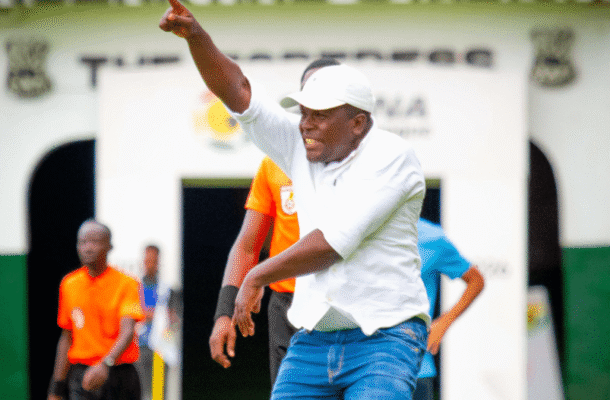 IMG_0879 | Ghanaguardian.com Man in a white polo and cap points forward while celebrating on a football pitch near the tunnel entry behind him