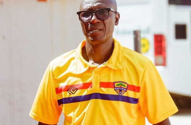 IMG_0895 | Ghanaguardian.com Smiling man in a bright yellow polo with red and blue stripes, wearing glasses outdoors.