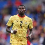 Ghana national football team player in yellow kit with number 5, running on the pitch during a match.