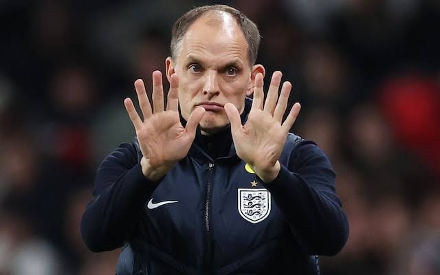 England football manager in a dark jacket, hands up with palms facing outward as if signaling 'stop'.