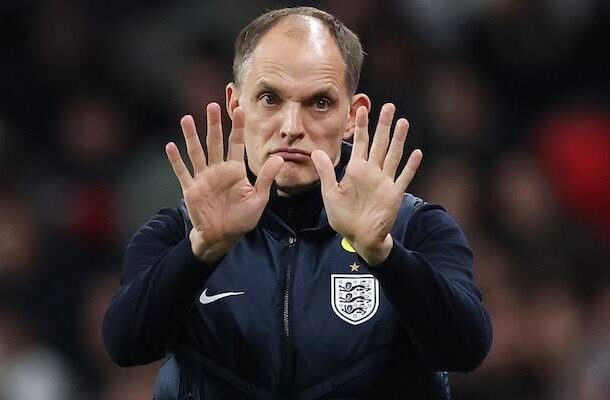 England manager Gareth Southgate raises both hands with palms outward on the touchline during a match gestureing calm or stop signals.