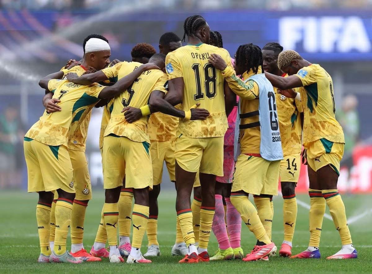 Soccer players in yellow uniforms form a huddle on the field before a match.