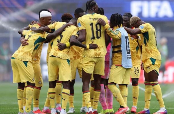 IMG_1047 | Ghanaguardian.com Soccer team in yellow jerseys huddles together on a green field before a match, players with numbered backs forming a circle behind the goalie in pink kit