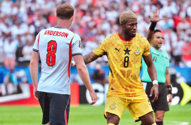 Two soccer players face off on the field; one in light blue with 'ANDERSON 8' and the other in yellow with a black star, during a match.