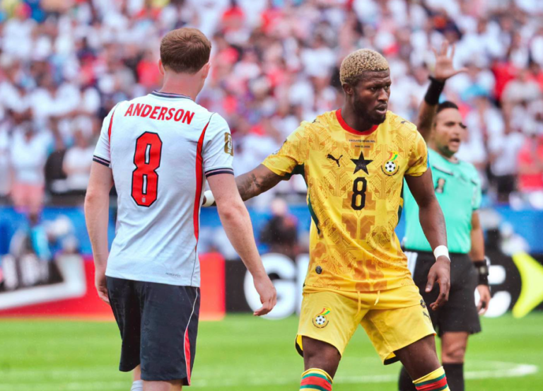 Two soccer players face off on the field; one in light blue with 'ANDERSON 8' and the other in yellow with a black star, during a match.