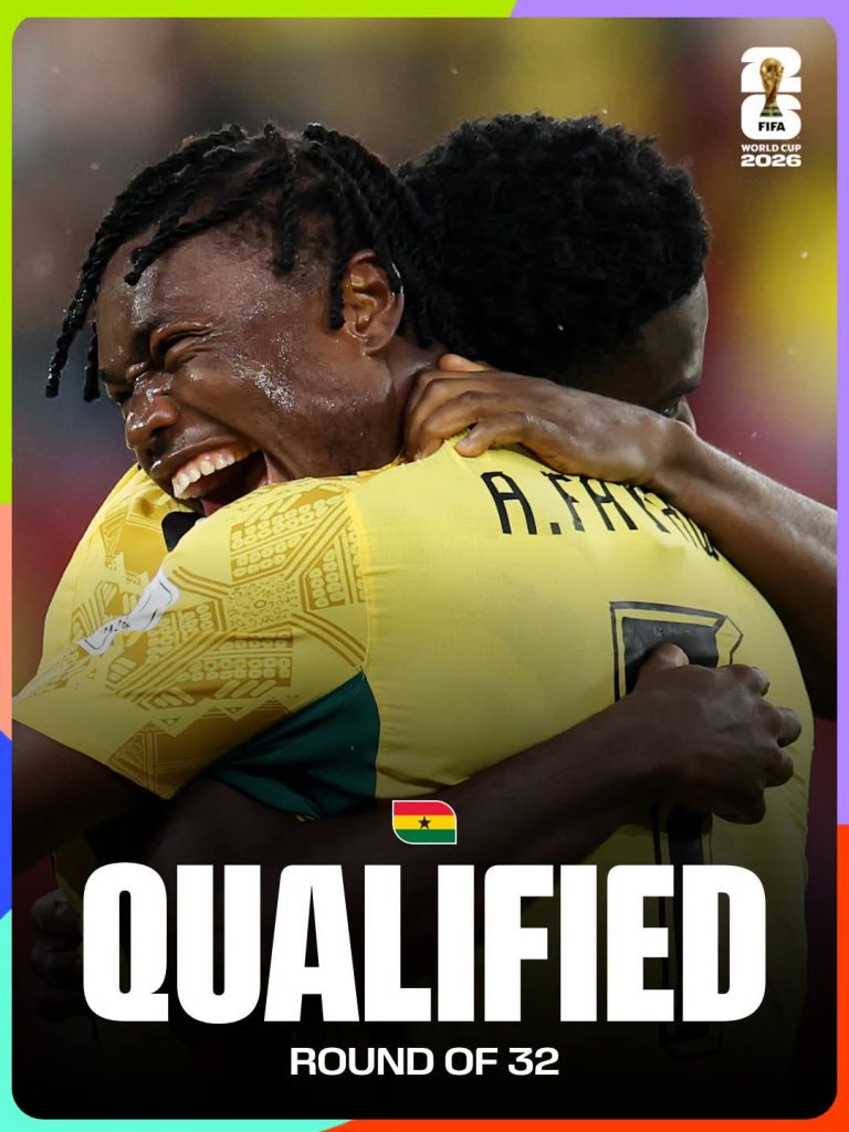 Two Ghanaian football players embrace in celebration, with the word 'QUALIFIED' and 'ROUND OF 32' on a graphic that includes the FIFA World Cup 2026 logo.