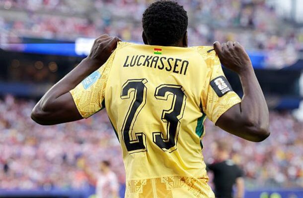 Soccer player seen from behind in a yellow jersey with name Luckassen and number 23, celebrating on the field.