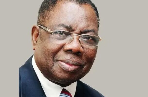 James Victor Gbeho | Ghanaguardian.com Portrait of a middle-aged man wearing a navy suit, white shirt, red-blue striped tie, and glasses, facing the camera against a gray background.