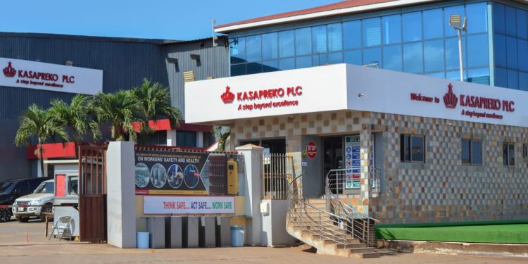 Kasapreko PLC storefront with bright sign and steps leading to entrance in a sunny lot