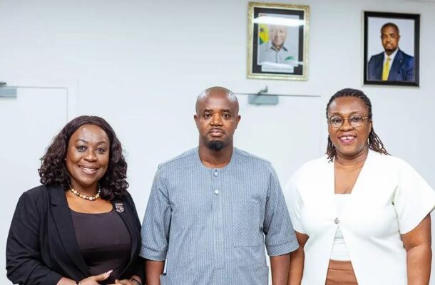 NPA | Ghanaguardian.com Three professionals posing in an office: man center in a light blue tunic, women on either side in dark and white outfits; framed portraits on the wall behind.