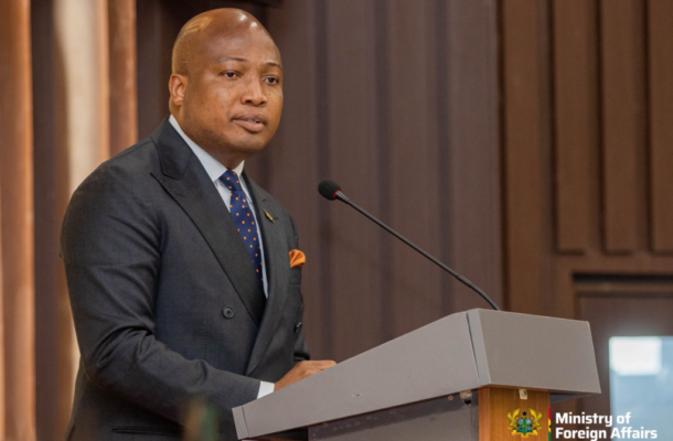 Okudzato Ablakwa | Ghanaguardian.com Man in a dark suit and orange pocket square speaks at a podium with a microphone, ministry seal visible on the lectern.