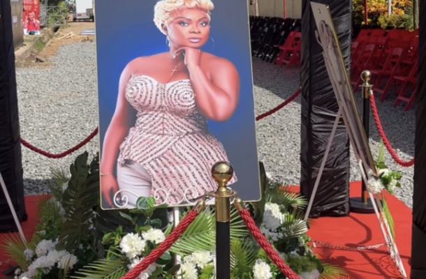 Screenshot-2026-06-01-at-44144-AM-717x424 | Ghanaguardian.com Portrait of a woman in a sparkling strapless dress on a stand, surrounded by white flowers and red rope barriers at an outdoor event