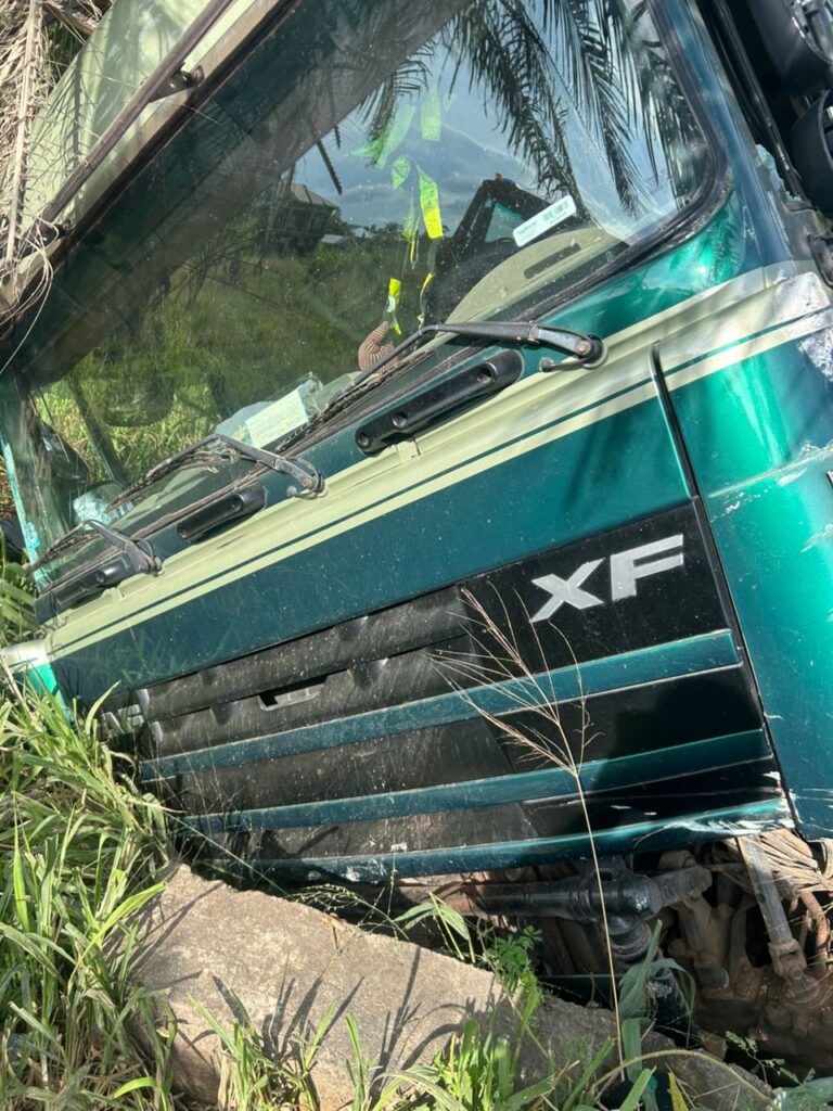 WhatsApp-Image-2026-06-13-at-221459-1-768x1024 | Ghanaguardian.com Green XF truck cab leaning onto a concrete edge with vegetation around, suggesting an accident or breakdown scene.