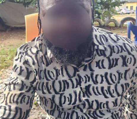 William Opoku | Ghanaguardian.com Person with braided hair and a black-and-white patterned shirt sitting outdoors; face blurred, trees and chairs in the background.
