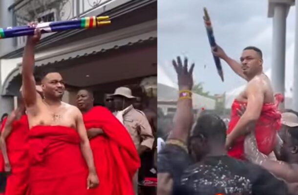 akofena | Ghanaguardian.com Man wrapped in red fabric raises a large colorful ceremonial rocket amid a cheering crowd at an outdoor event (composite image).