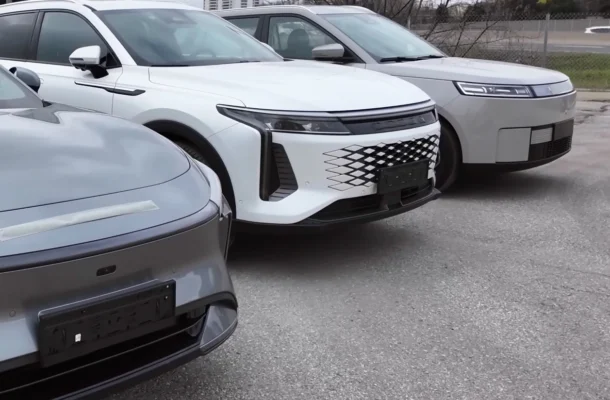 Row of modern SUVs parked in an outdoor lot, centered on a white SUV with a distinctive lattice grille