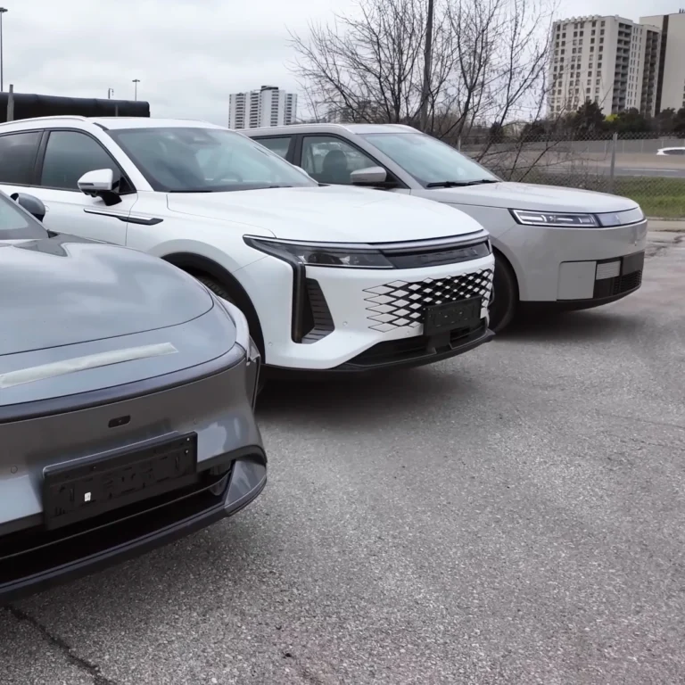 Row of modern SUVs parked in an outdoor lot, centered on a white SUV with a distinctive lattice grille