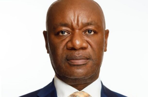 image_870x_6a34e0d0ac884 | Ghanaguardian.com Portrait of a bald Black man in a navy suit and peach tie, looking at the camera with a neutral expression.