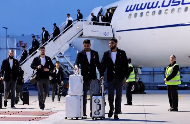 iran | Ghanaguardian.com Group of men in suits pulling luggage away from a white passenger plane on the tarmac, stairs and ground crew nearby.