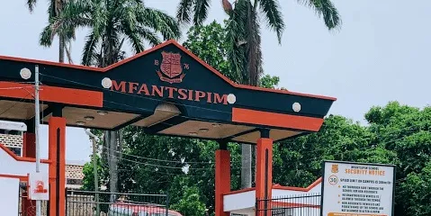 mfantsipim | Ghanaguardian.com Entrance gate to Mfantsipim School with red pillars and crest; tropical trees in the background.