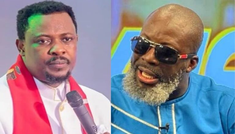 Two men side by side: left in a white suit with a red scarf holding a microphone; right in blue attire with sunglasses and a gray beard.