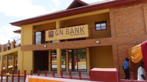Facade of a GN Bank branch with a yellow and brick exterior and a sign reading 'GN BANK The People's Bank' above the entrance; a few people near the doorway.