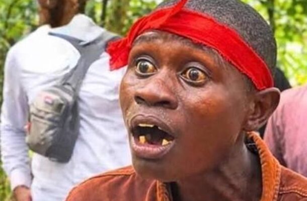 IMG-20260705-WA0023 | Ghanaguardian.com Close-up of a man wearing a bright red headband, with a shocked expression and missing teeth, outdoors in a wooded area.