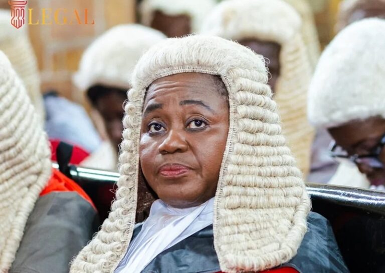 Female lawyer wearing a white barrister wig sits in a courtroom, with a 'LEGAL' logo in the top-left corner.