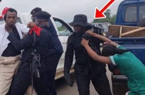 IMG-20260728-WA0062-2 | Ghanaguardian.com Group of men restraining a person near a pickup truck; an armed officer in black watches, with a red arrow highlighting the scene.