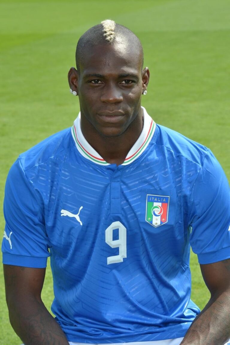 Portrait of a male soccer player wearing the Italy national team jersey (number 9) on a green field.