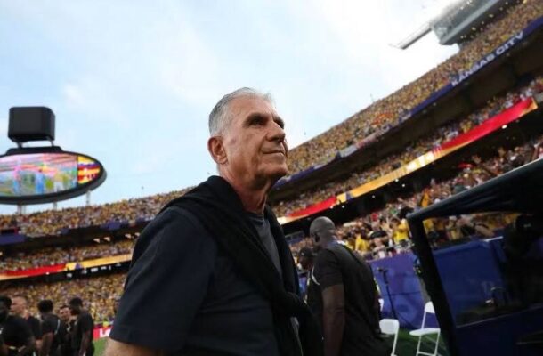 IMG_1190 | Ghanaguardian.com Older man in a black polo walks along the sideline of a crowded football stadium.