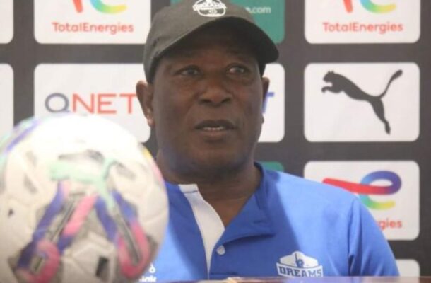 IMG_1208 | Ghanaguardian.com Man in a blue polo and cap speaks at a press conference with a soccer ball in the foreground and sponsor logos behind him.