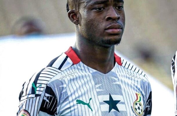 Young male soccer player wearing a white jersey with green accents and the number 23, looking focused on the field.