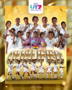 Group of Ghanaian women's soccer players in white uniforms pose together, celebrating qualification with a large 'QUALIFIED' banner and Ghana flag motif in the foreground.