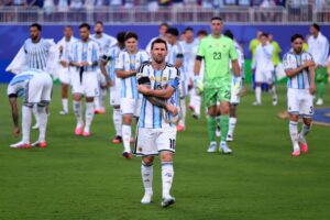 Argentina national team players in light blue and white striped kits walk onto the field; central player wears number 10 shirt.