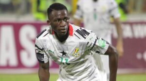 Ghana national football team player in a white kit with number 17, sprinting on the field during a match.