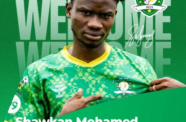Portrait of Shawkan Mohamed in Aduana Football Club's green jersey, with club crest visible and his name/text overlay in the background.