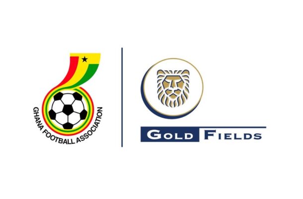 Ghana Football Association crest with a soccer ball and rainbow ribbon, next to Gold Fields logo with a lion’s head in a circle.