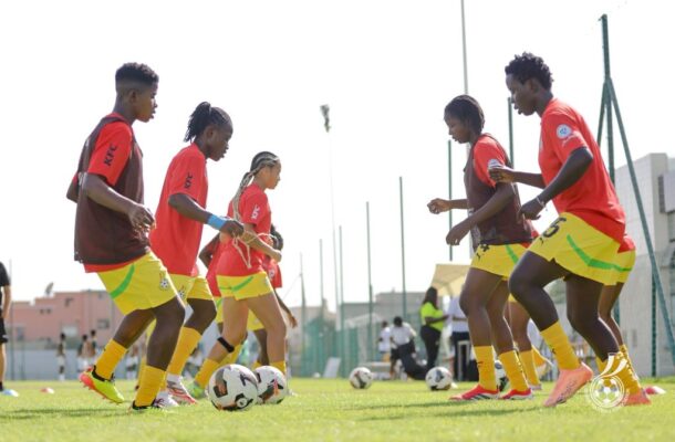 IMG_1338 | Ghanaguardian.com Youth soccer players in red training shirts and yellow shorts jogging and dribbling on a sunny grass field during practice.