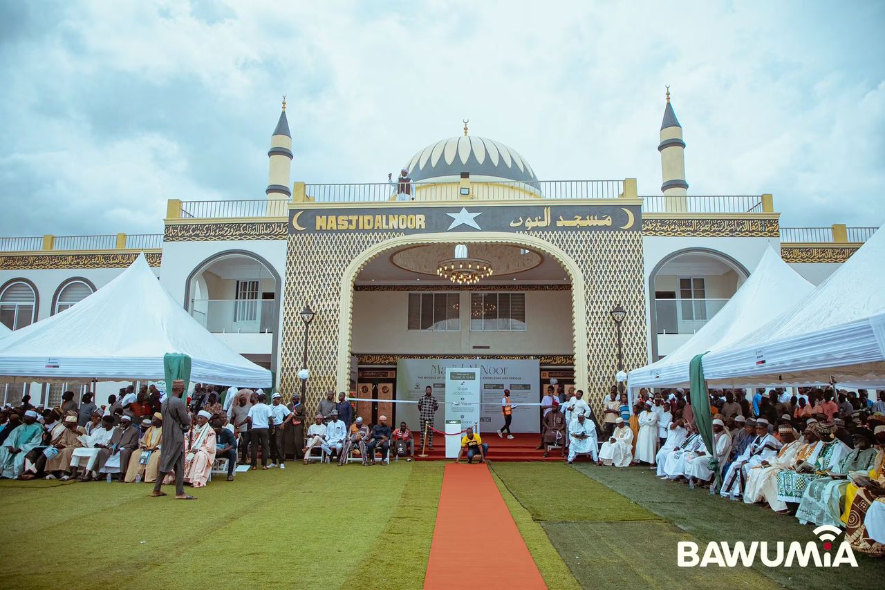WhatsApp Image 2026-07-06 at 115551 1 | Ghanaguardian.com Outdoor ceremony at a mosque with a large dome and minarets, crowds seated under white tents and a red carpet leading to the entrance.