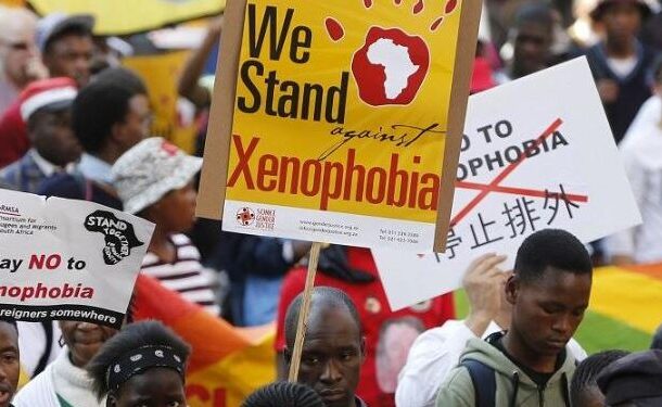 Xenophobic-1-743x375 | Ghanaguardian.com Crowd of protesters holding anti-xenophobia signs, including a yellow banner that says 'We Stand against Xenophobia' and other placards.