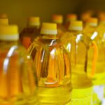 Row of yellow-capped oil bottles lined up on a store shelf