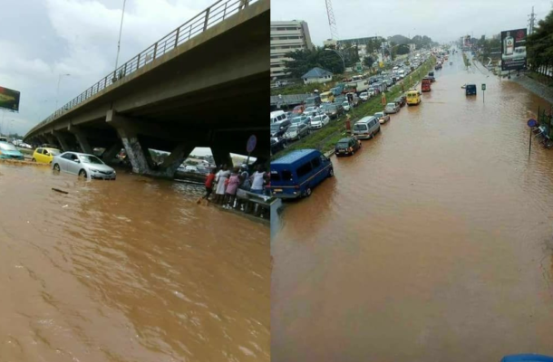 image-407 | Ghanaguardian.com Two-panel photo of urban flooding: left shows cars and pedestrians near a raised overpass with floodwater surrounding vehicles; right shows a wide main road almost completely flooded, with slow traffic and brown water covering multiple lanes.