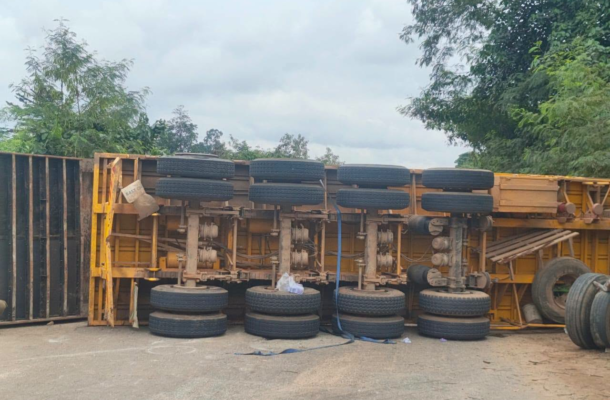image-732 | Ghanaguardian.com Yellow truck trailer overturned on its side in a yard, with wheels stacked along the frame.