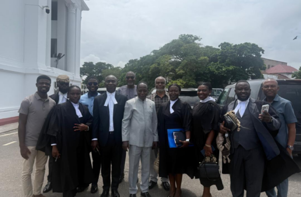 image-781-696x522 | Ghanaguardian.com Group of professionals posing outdoors in front of a white neoclassical building; several wear black legal gowns with white neck bands, others in suits.