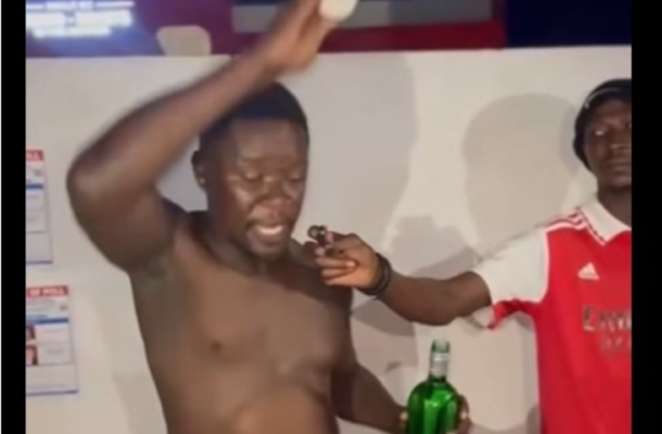 image_2026-07-12_112135353 | Ghanaguardian.com Shirtless man raises his arm as another man in a red jersey holds a microphone near him and a green bottle in his hand.