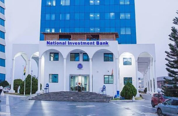 National Investment Bank building with white arches and a blue sign, entrance steps, and a tall blue glass office tower behind it.
