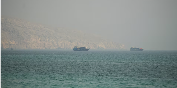 Two small boats on a calm turquoise sea with a hazy rocky coastline in the background.”,