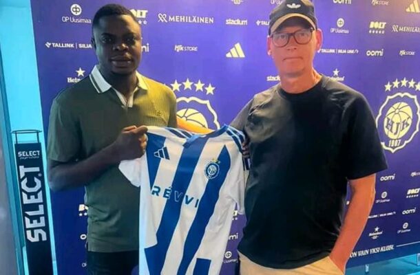 victory | Ghanaguardian.com Two men pose with a blue-and-white striped soccer jersey in front of a purple backdrop covered with sponsor logos.